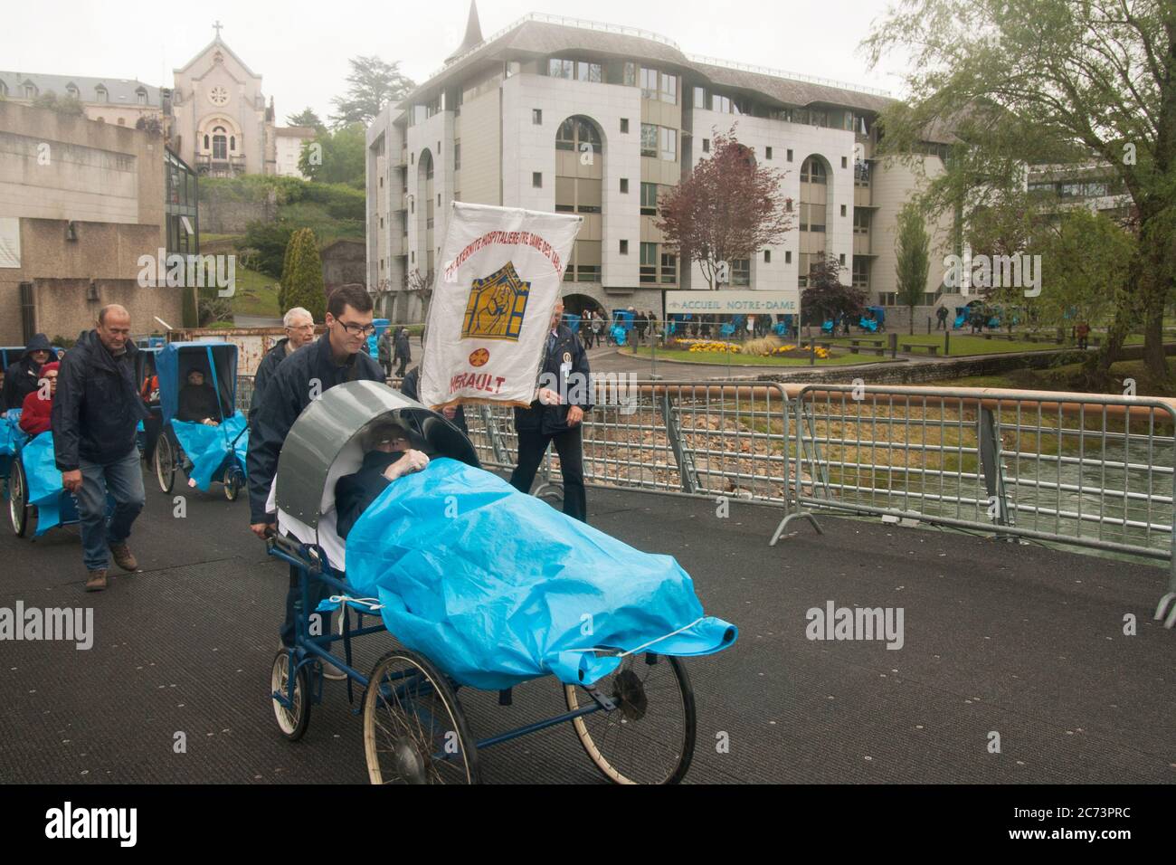 Apr 28. 2014 Lourdes France A row of seriously ill people, unable to walk lying on wheeled stretcher. They go to the sanctuary hoping for healing. Stock Photo