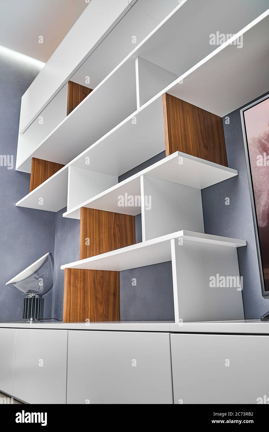 Modern bookcase. White and wooden bookshelves in contemporary interior