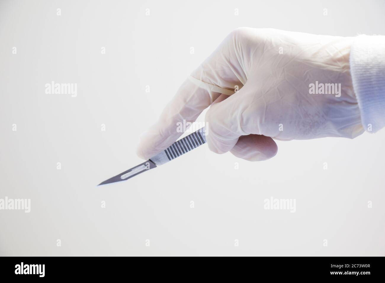 Surgery knife holding on the white background, studio shot. Operation