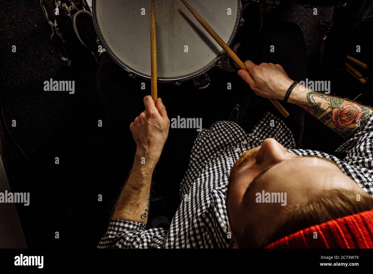 young caucasian drummer rehearsing on drums before rock concert