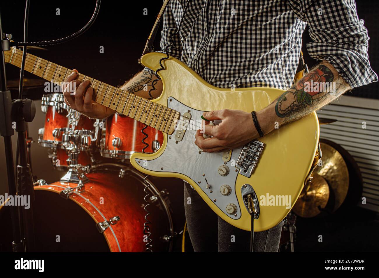 unrecognizable musician with electric guitar in recording studio. guitarist hold modern electric