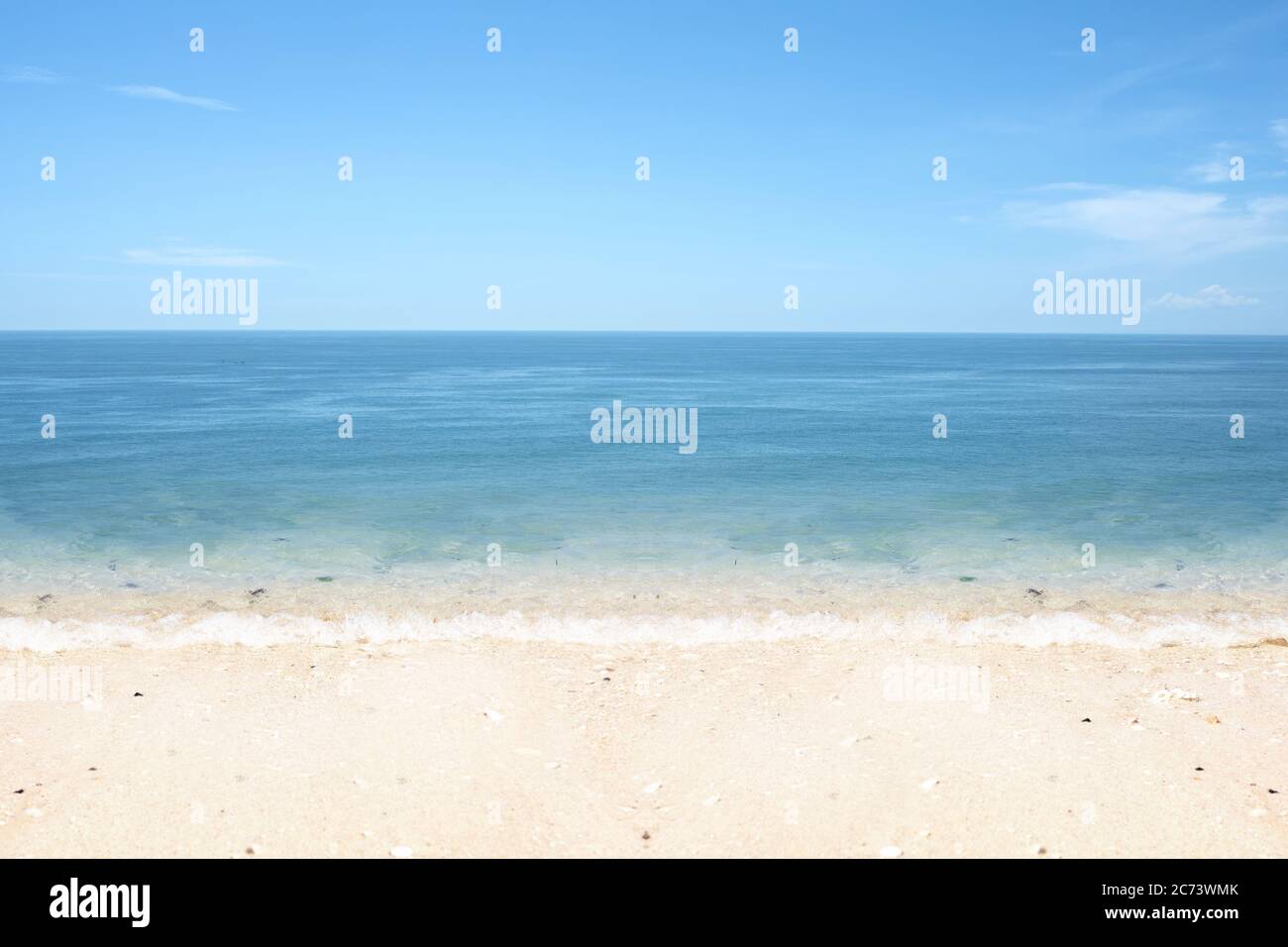 Sandy beach with the blue ocean and blue sky background Stock Photo - Alamy