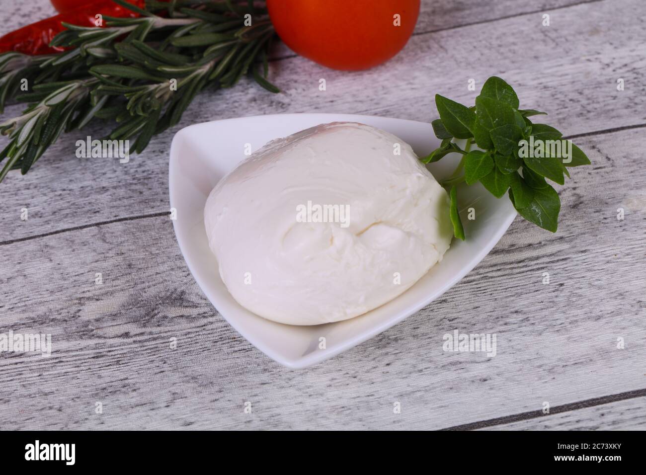 Italian Mozzarella cheese ball served basil and tomatoes Stock Photo