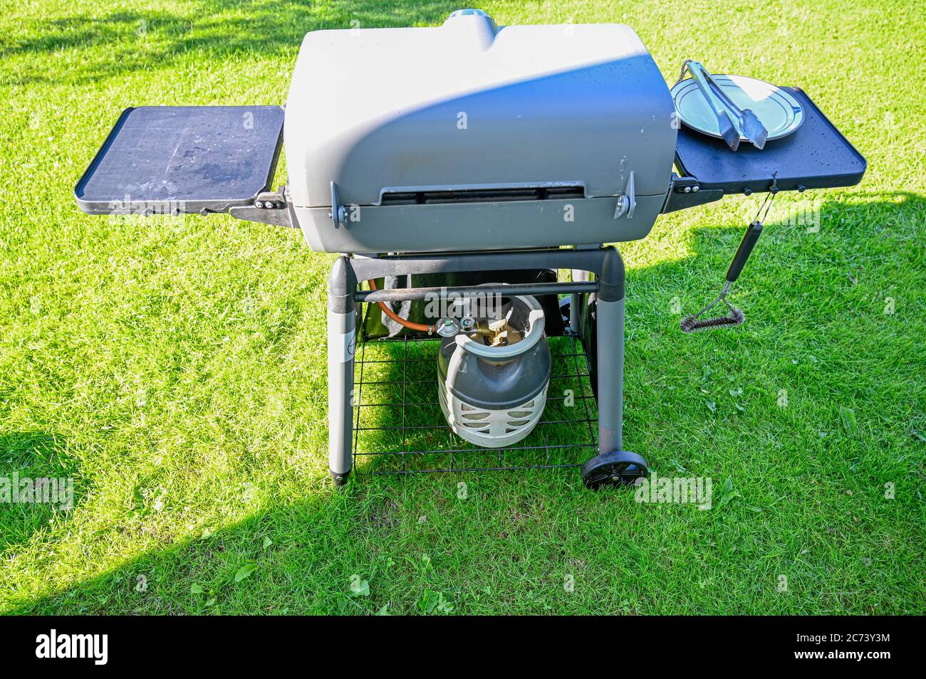 gas barbecue in garden on green grass Stock Photo Alamy