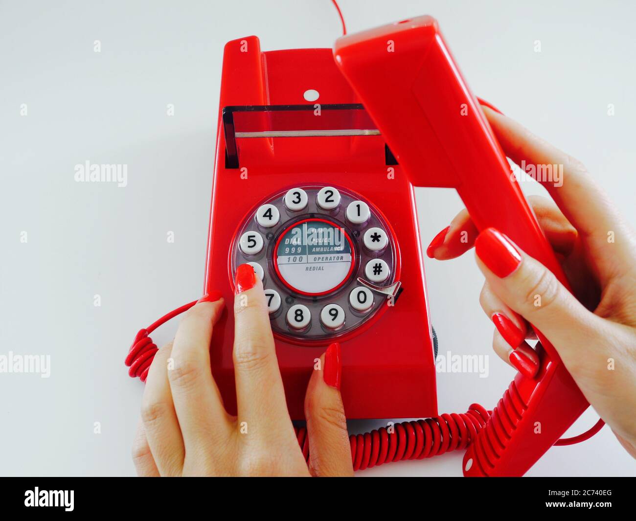 Female hands with red manicured nails make a telephone call, dialling the number 6 Stock Photo