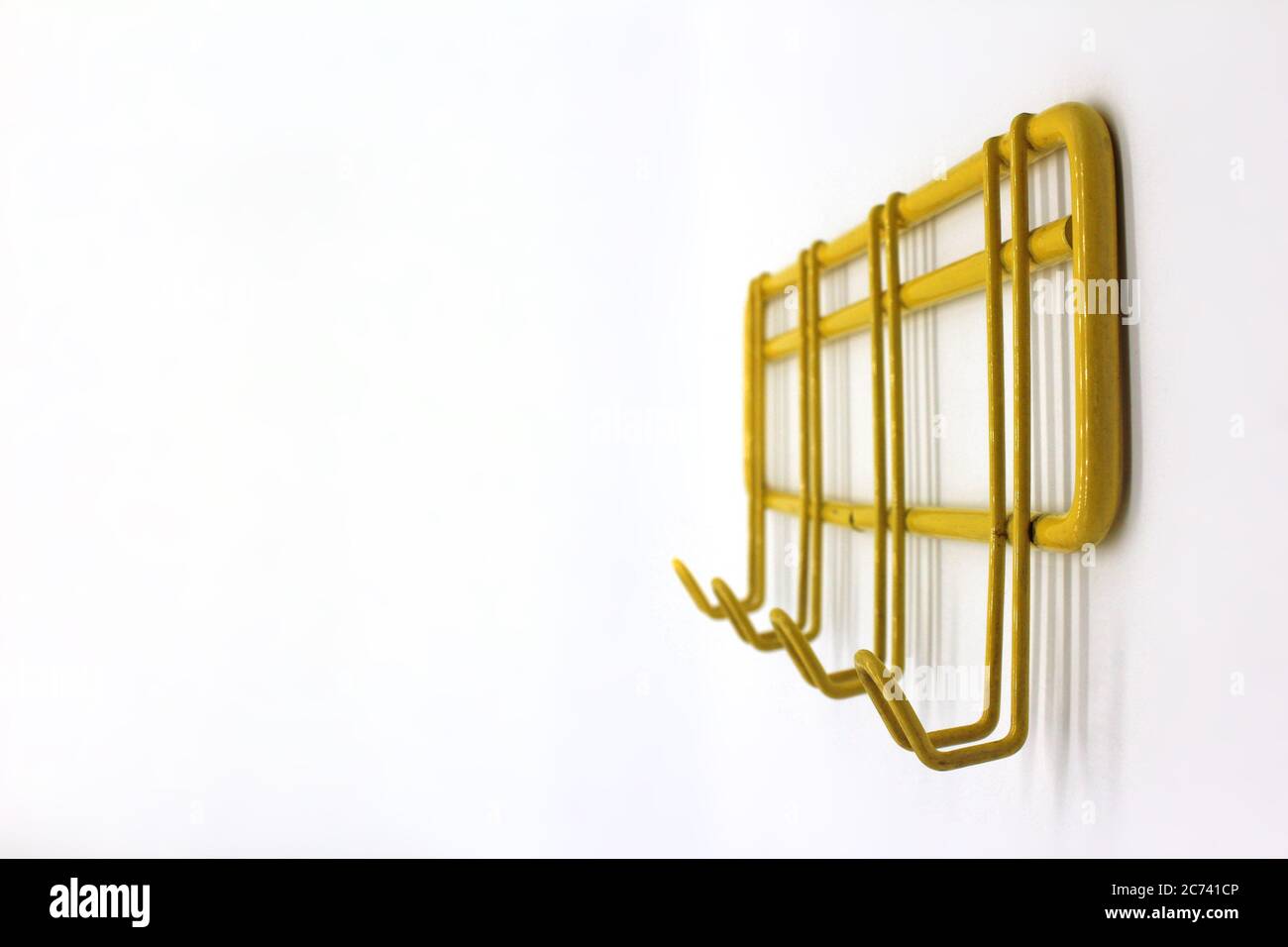 Yellow wall hanger isolated on a white background, close-up Stock Photo