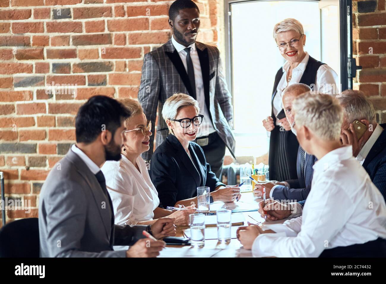 Group of businessmen wear suits sit at table in office and discuss new ...