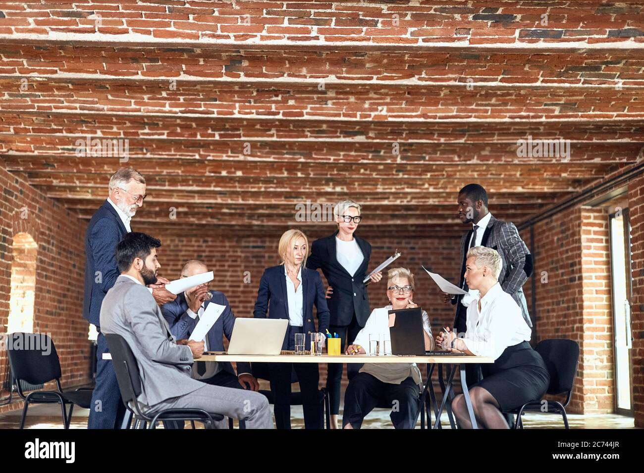 Group of eight businessmen wear suits discuss project in office Stock ...
