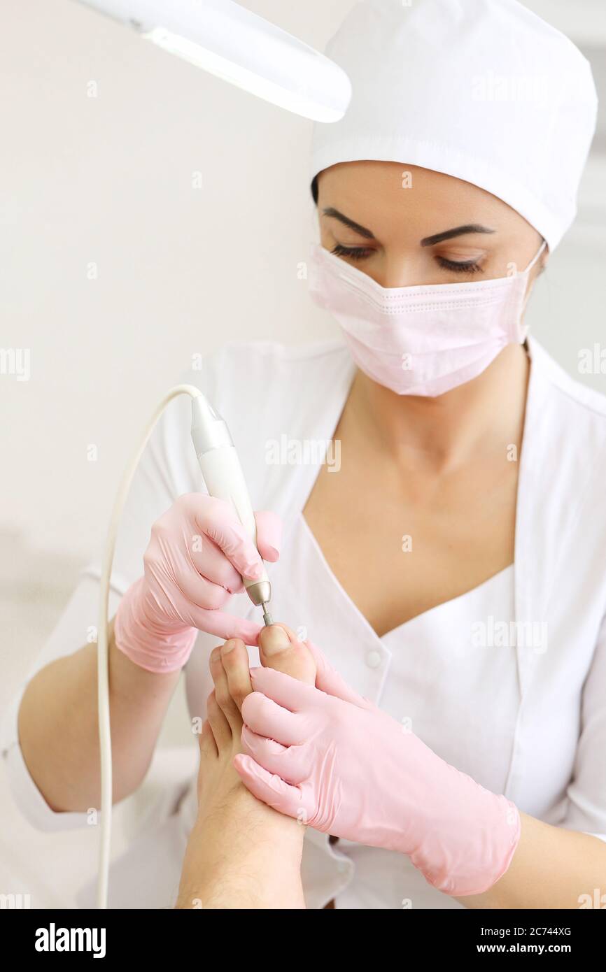 Patient on medical pedicure procedure, visiting podiatrist.Professional