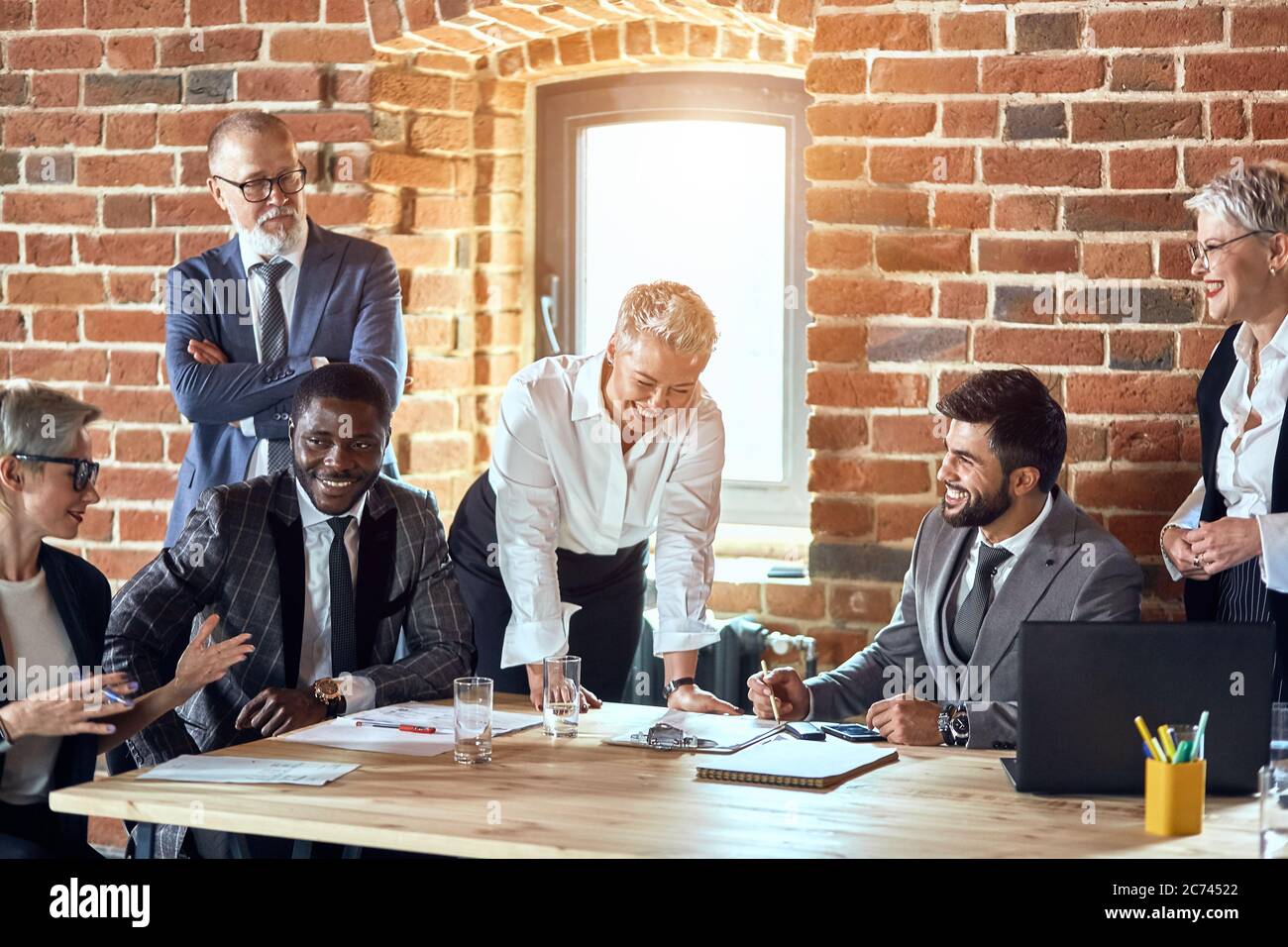 Group of businessmen wear stylish suits discuss new project. Blonde ...