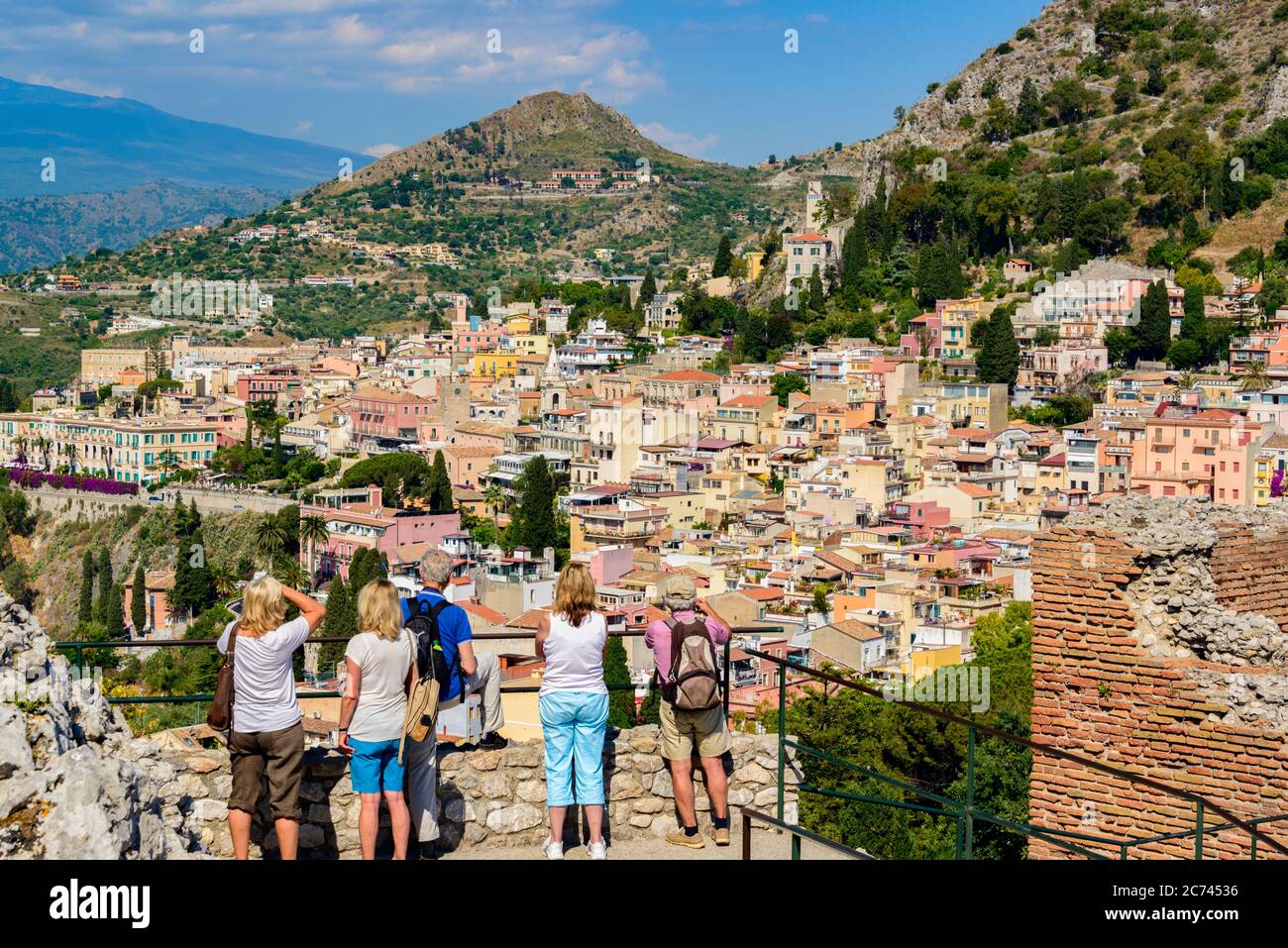 Touristen blicken vom Griechischen Theater Taormina auf die Stadt und den Ätna Stock Photo