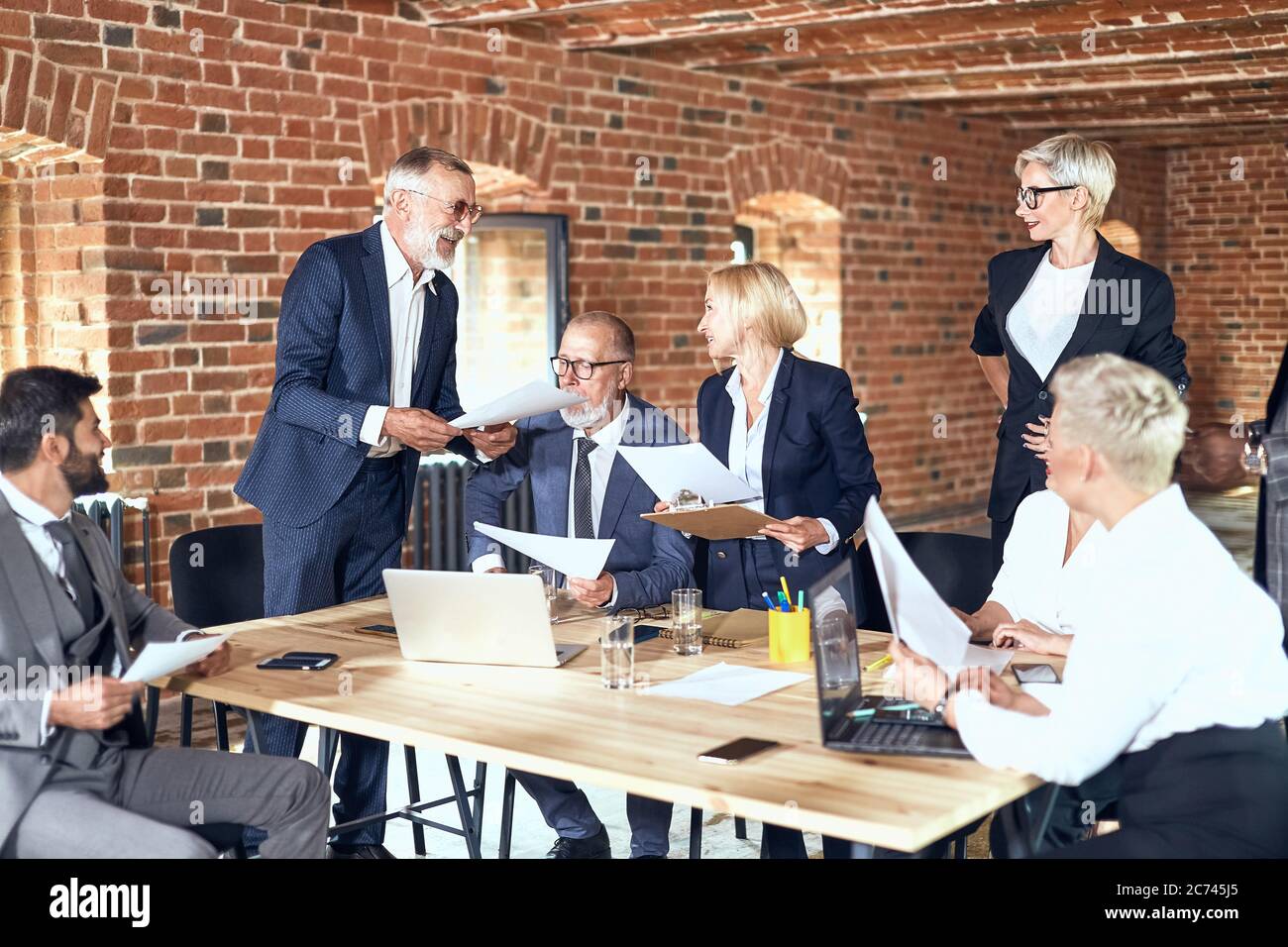 Group of businessmen wear stylish suits at table discuss project ...