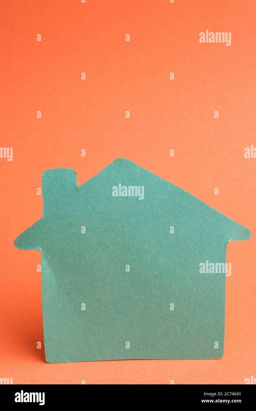 Green color house shape on orange background Stock Photo - Alamy