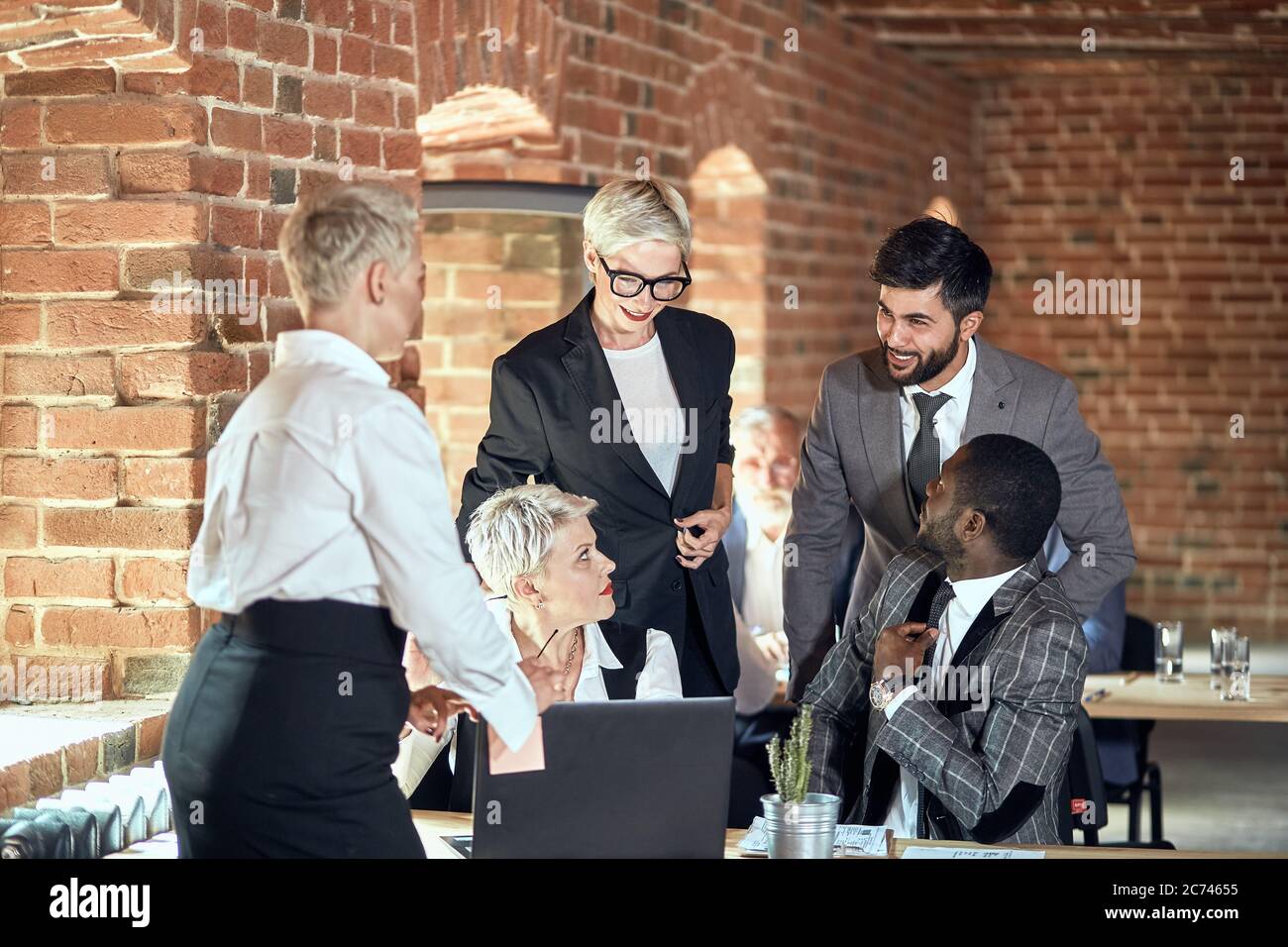 Five businessmen wear different office clothes discuss task at table in ...