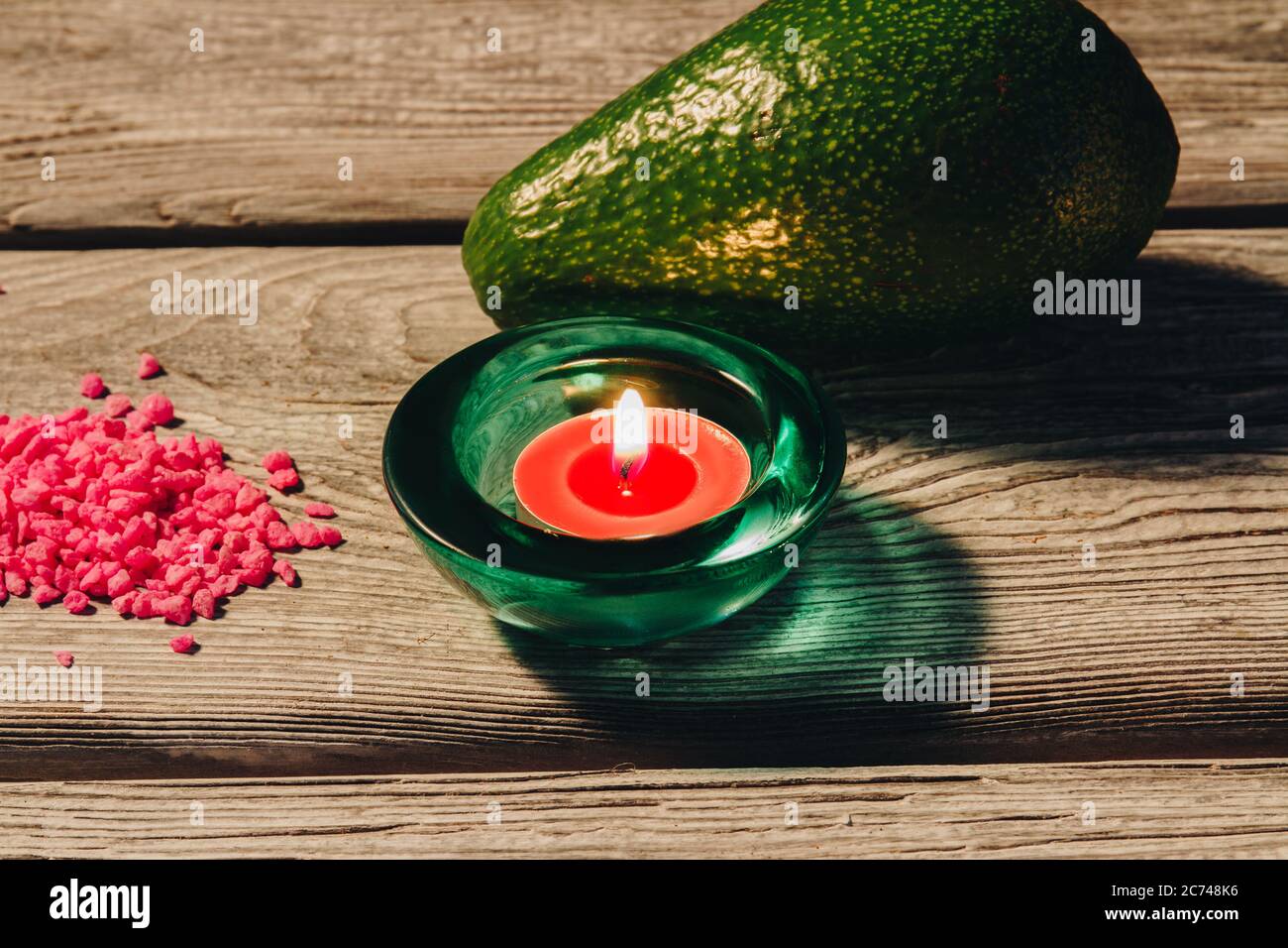 Natural avocado healthy for skin, burning candle and pink sea salts. Stock Photo