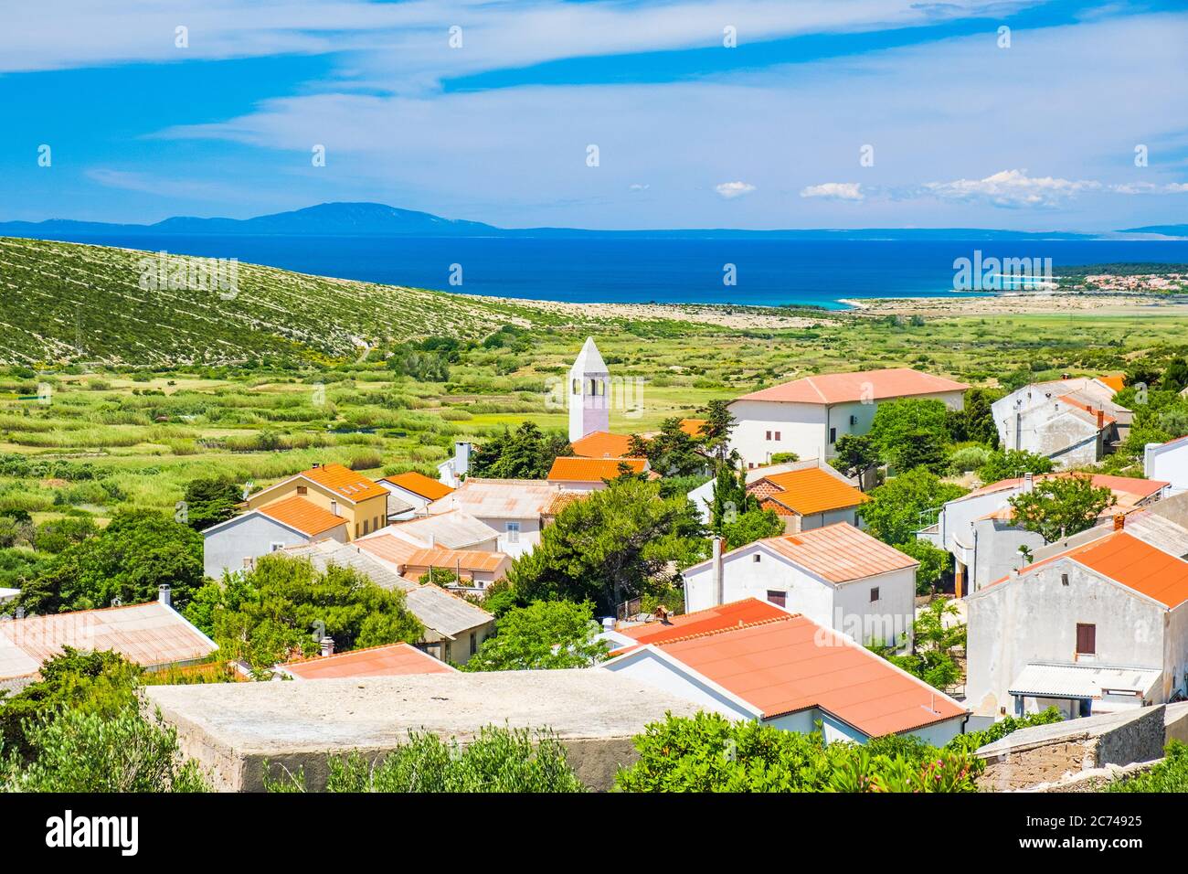Old village of Kolan on the island of Pag in Dalmatia, Croatia, Adriatic seascape in background Stock Photo