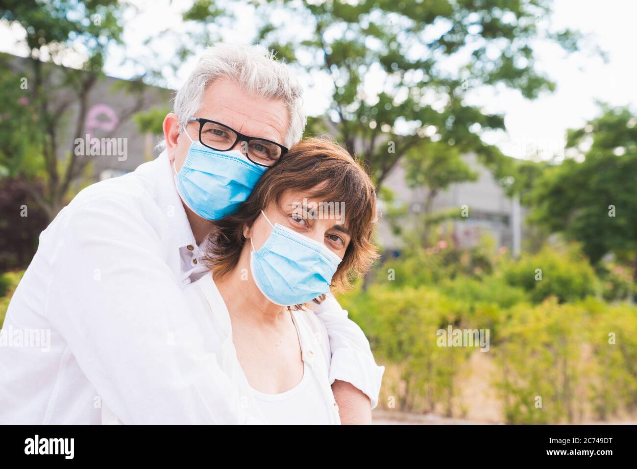 New normal. Family members hugging. Husband and wife hugging protected