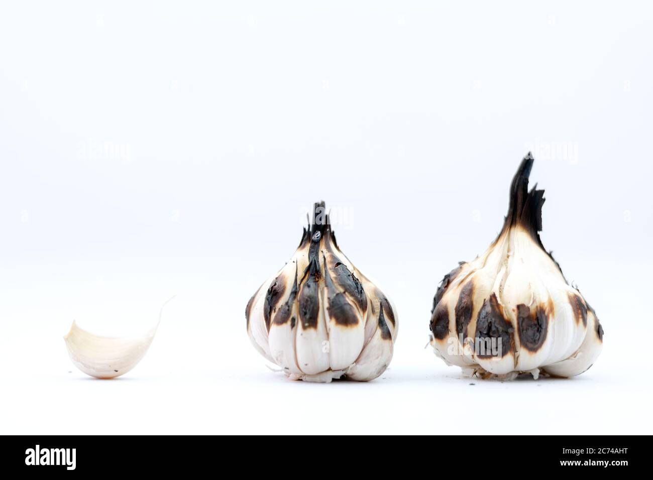 Roasted Garlic Cloves and Bulb in white background Stock Photo - Alamy