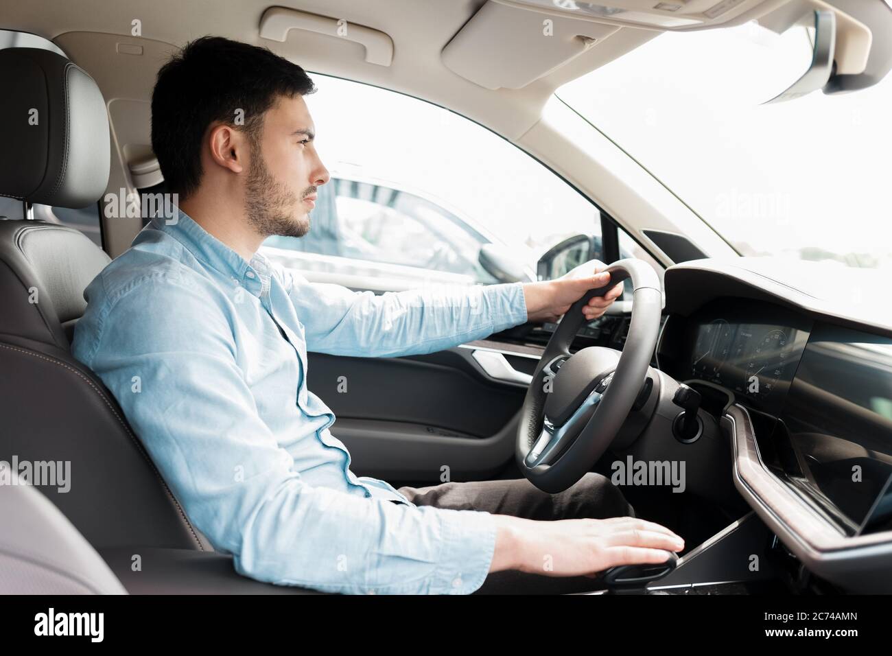 Man driving car. Side view of a man driving an expensive car Stock