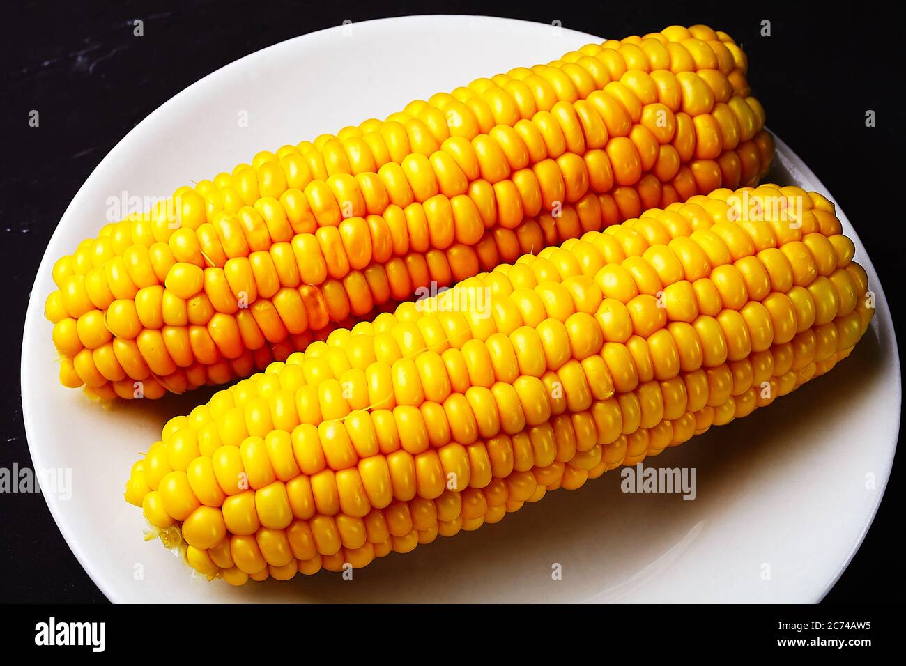 boiled corn on a white plate Stock Photo