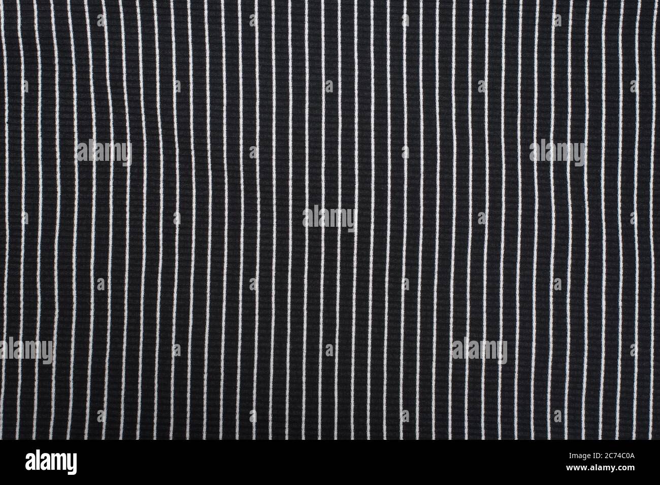 Black textured knitted fabric with white stripes. Vertical pattern Stock Photo