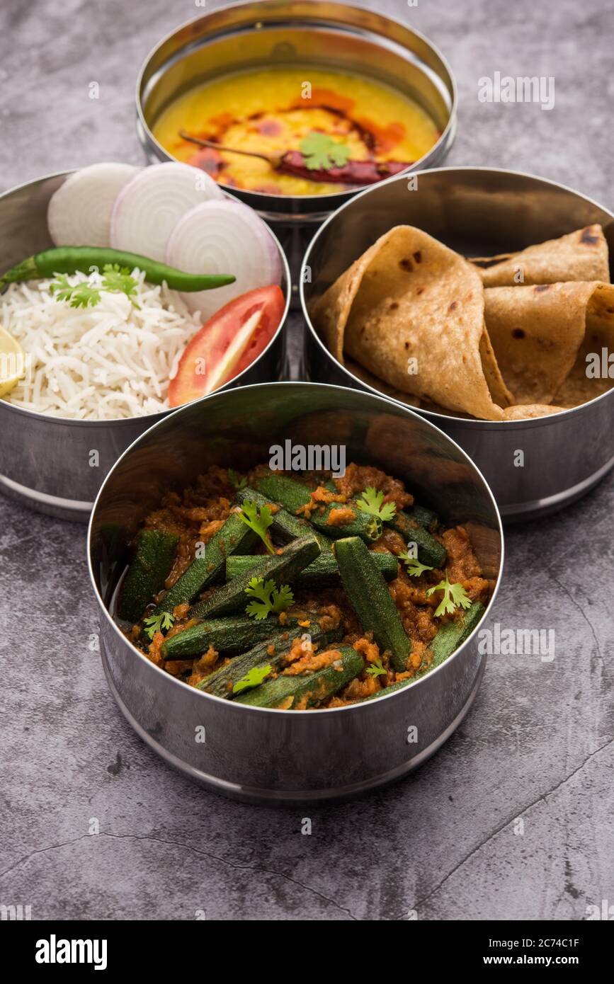 Indian vegetarian Lunch Box or Tiffin made up of stainless steel for office  or workplace, includes Dal Fry, Bhindi Masala, Rice with chapati and salad  Stock Photo - Alamy