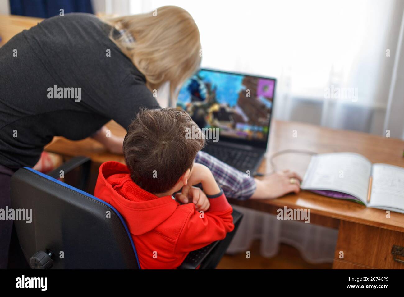 Mother turning off computer for computer addicted little gamer kid, internet and game dependency Stock Photo