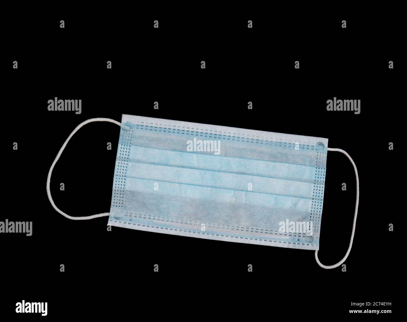 Single use Covid19 use surgical mask isolated on black with copyspace for your comment. Stock Photo
