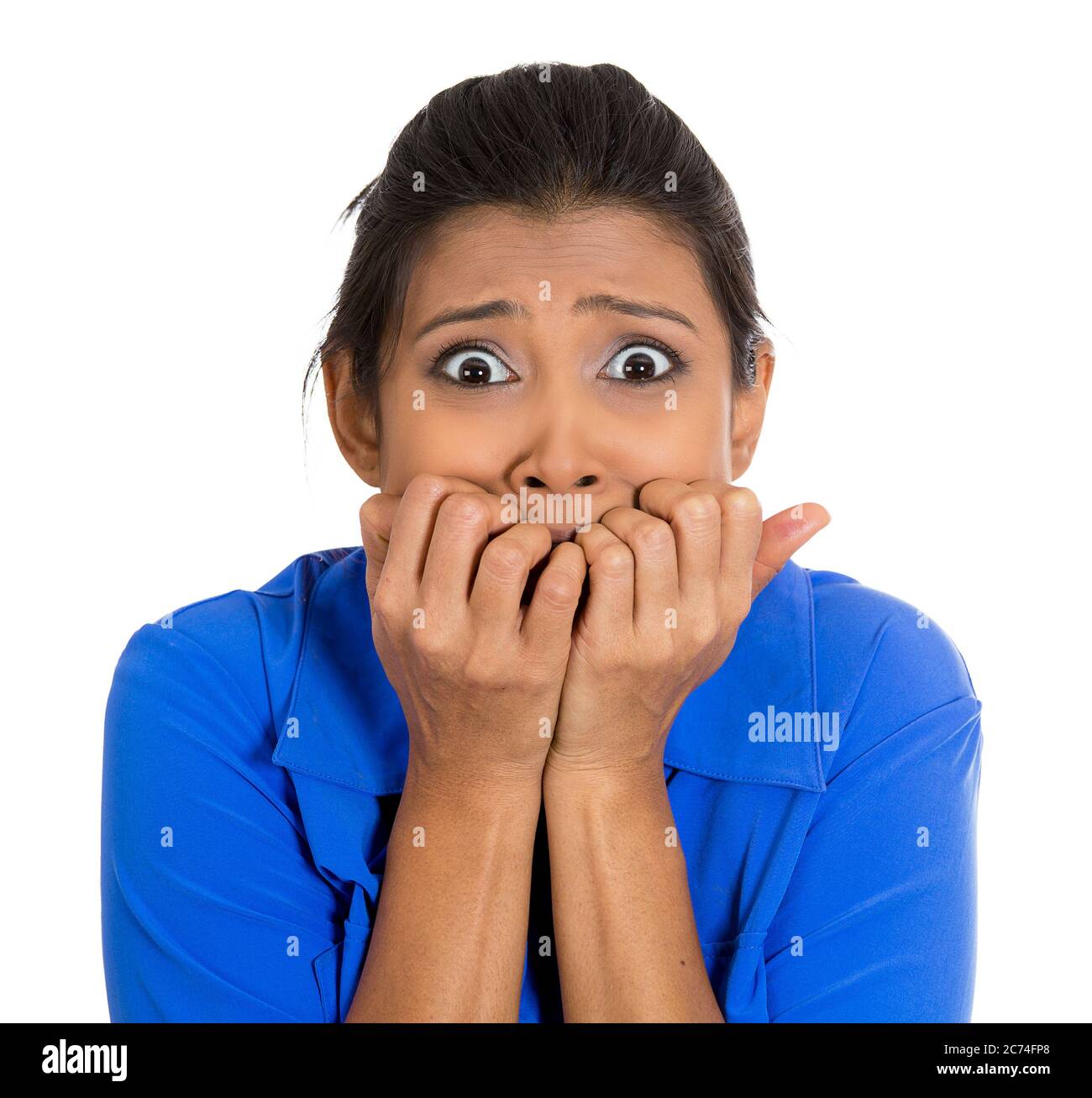 Portrait of a young woman biting her nails and looking anxious worried isolated on white background. Stock Photo