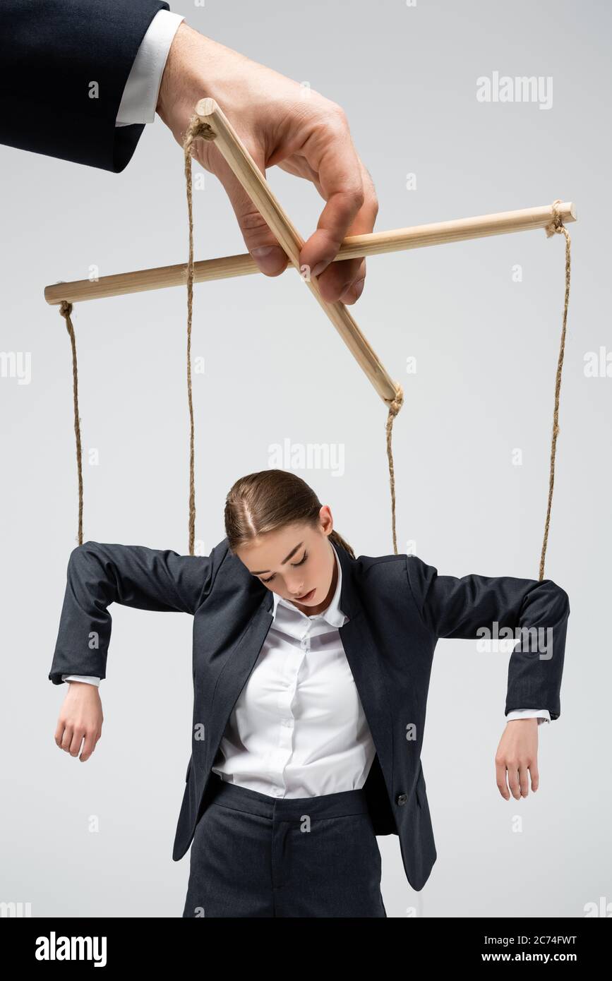 cropped view of puppeteer holding businesswoman marionette on strings  isolated on grey Stock Photo - Alamy