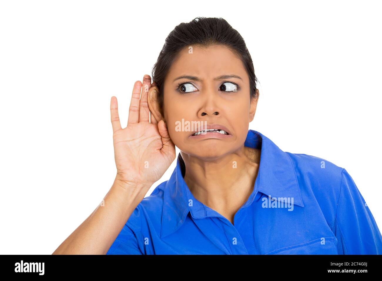 Portrait of a nosy worried woman with hand to ear gesture listening to a gossip conversation Stock Photo