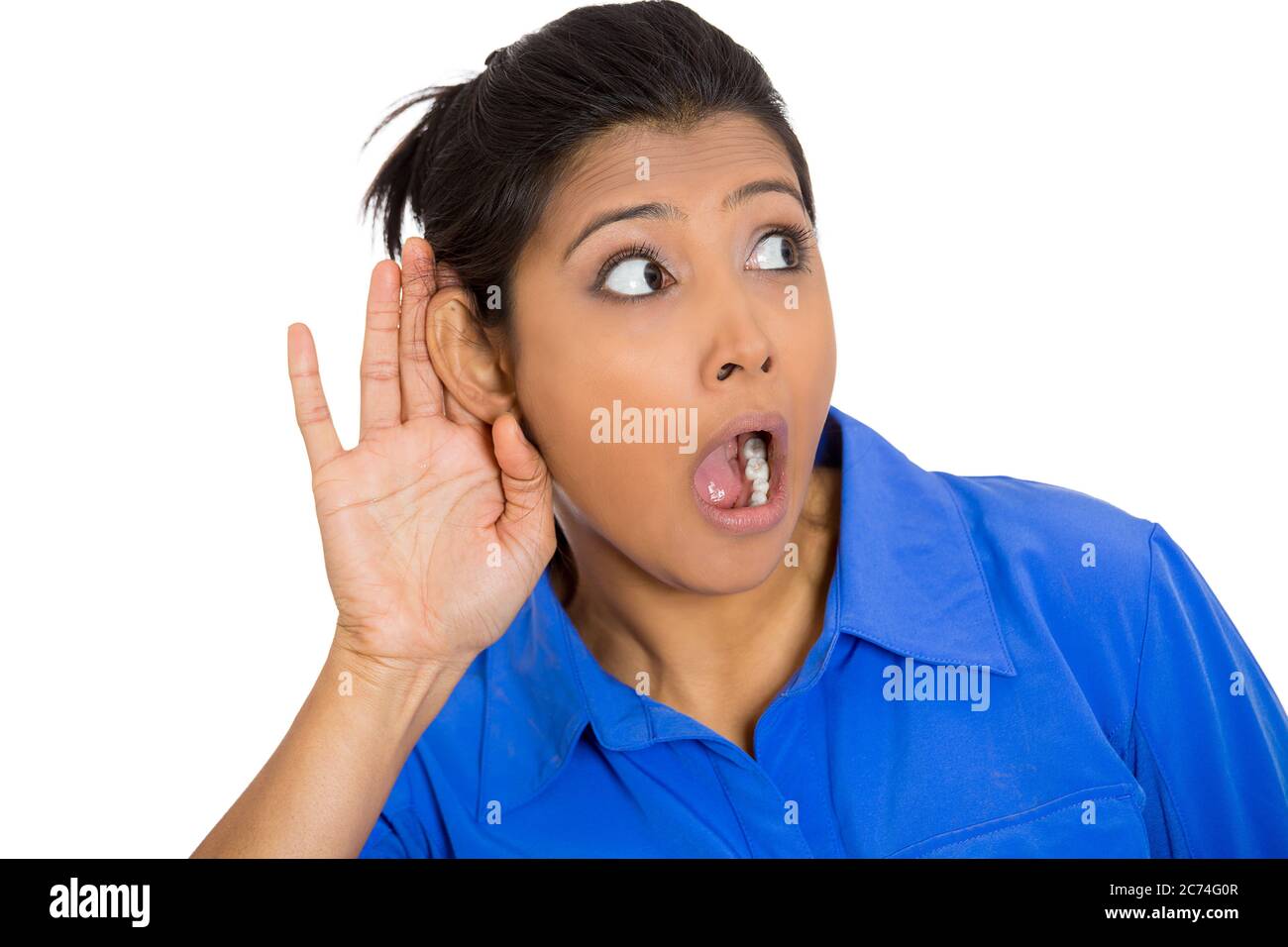 Portrait of a nosy shocked woman with hand to ear gesture listening to ...