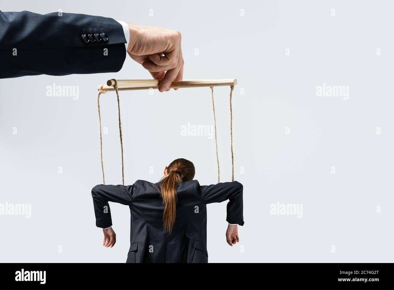 cropped view of puppeteer holding businesswoman marionette on strings  isolated on grey Stock Photo - Alamy