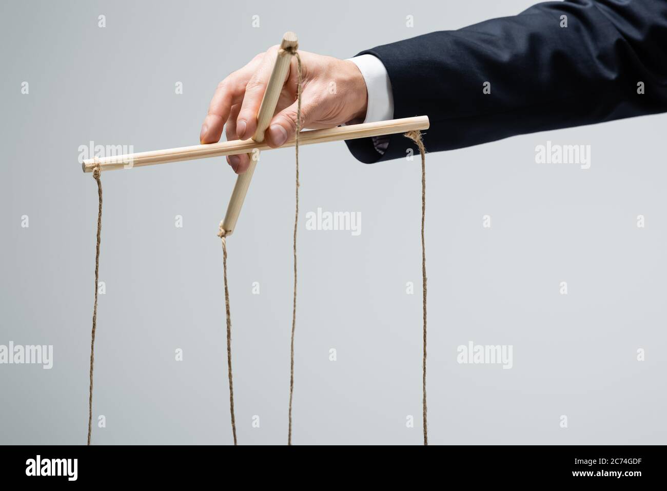 cropped view of puppeteer holding businesswoman marionette on strings  isolated on grey Stock Photo - Alamy