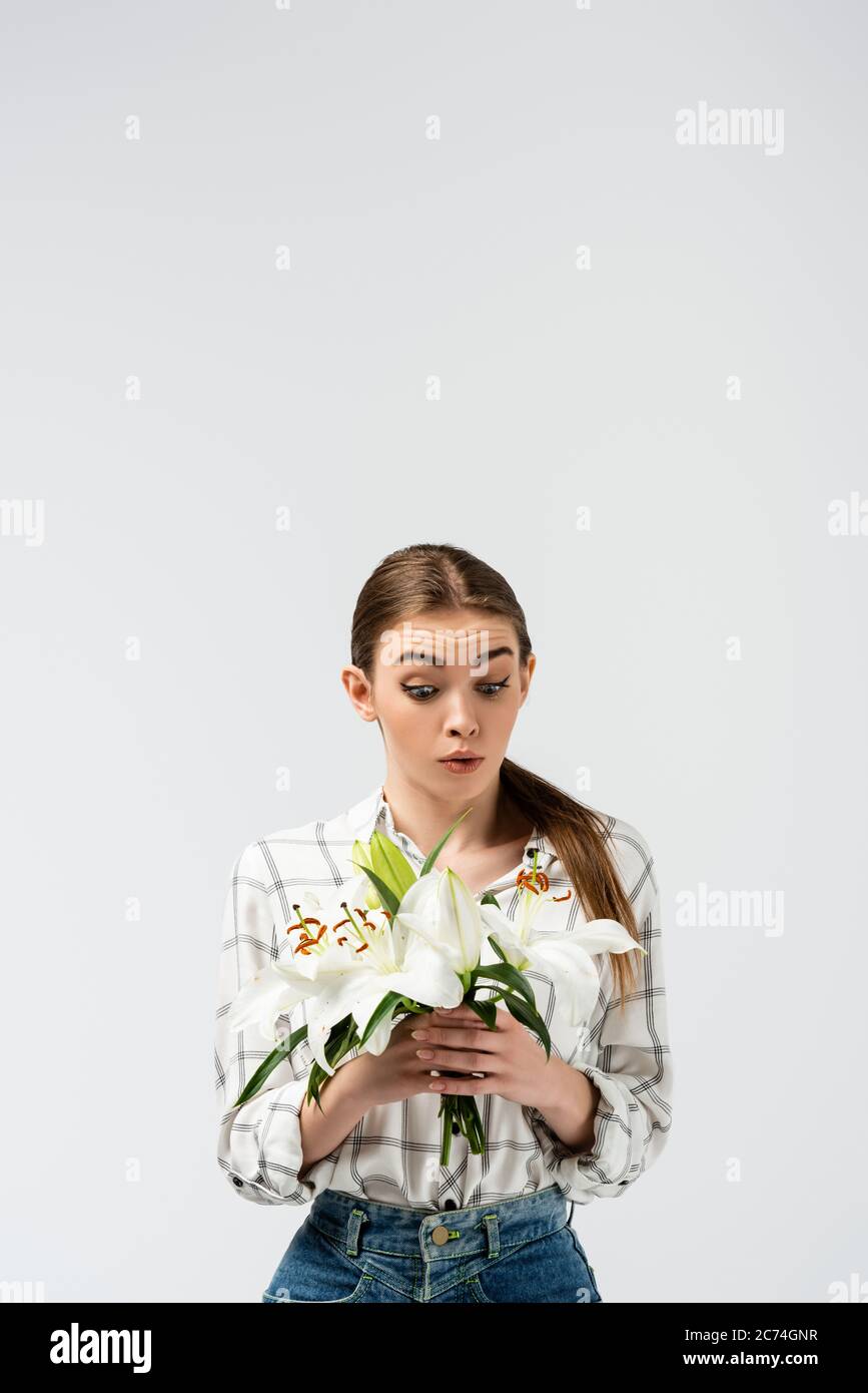 shocked attractive girl posing like puppet with flowers isolated on ...