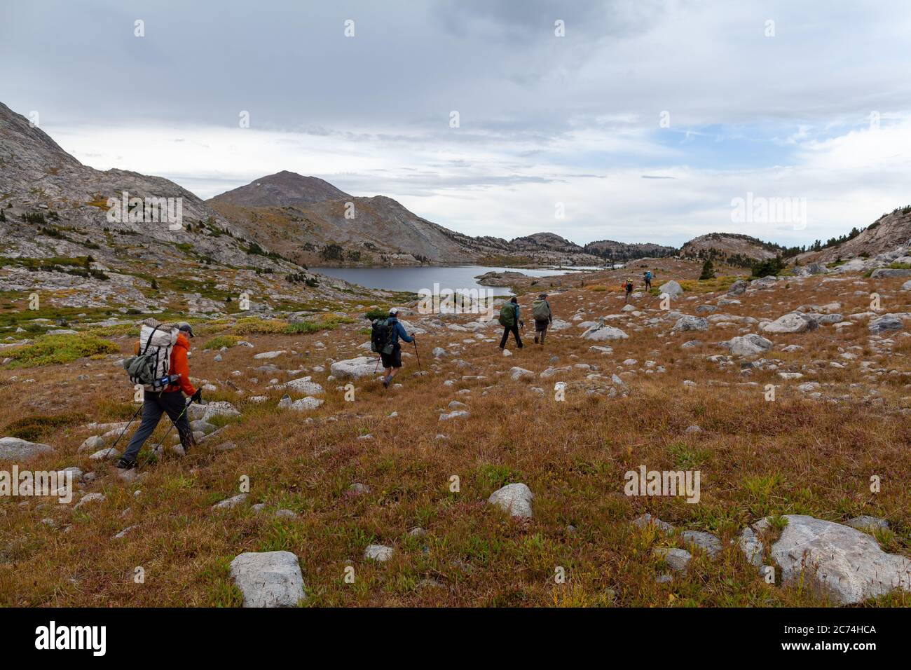 A group of backpackers hike southwest on the Europe Canyon Trail in Wyoming's Wind River Range. Medina Mountain and Lake 10542 are seen the background Stock Photo
