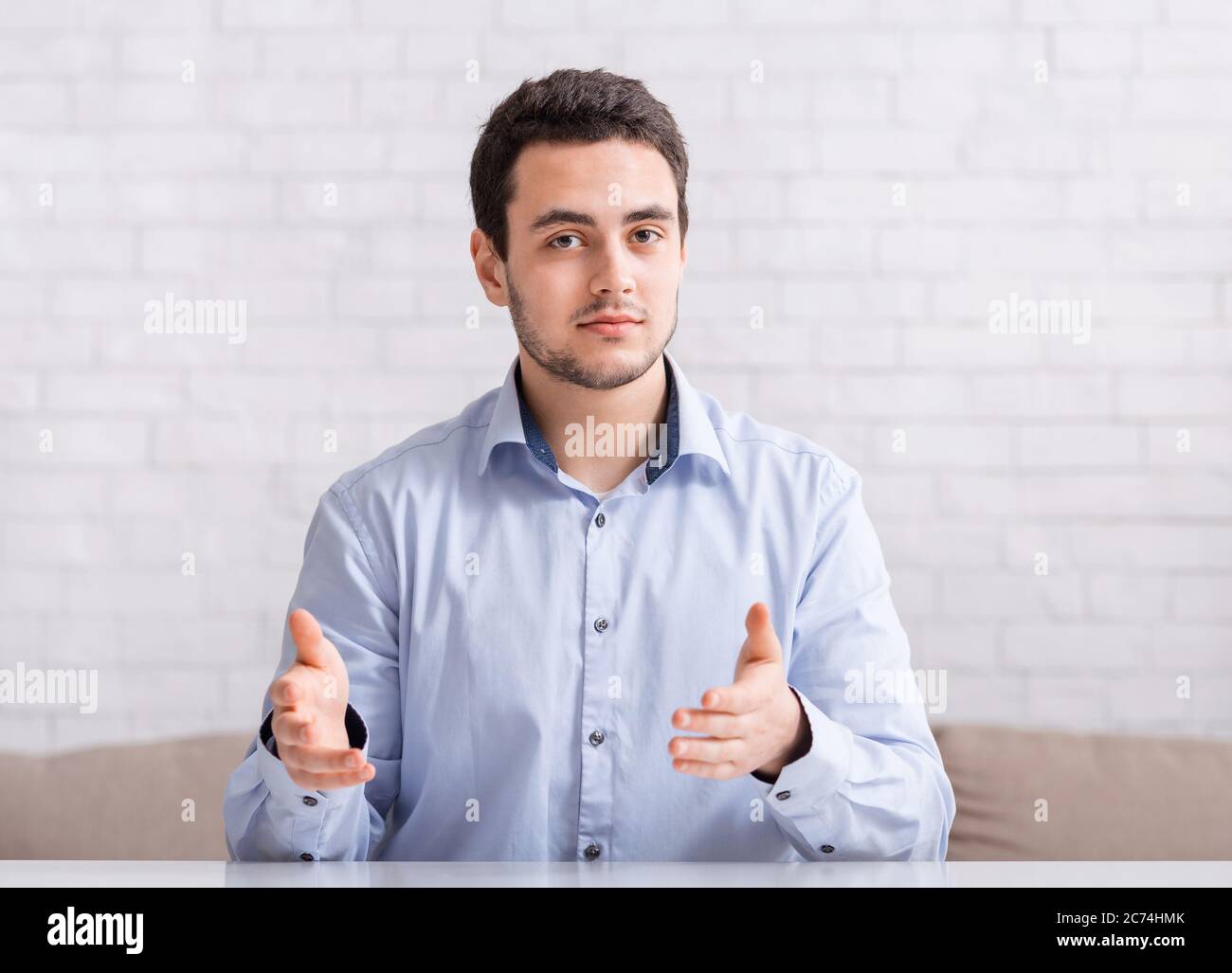 Explain and gesticulate. Mn in shirt works from home and make video conference Stock Photo