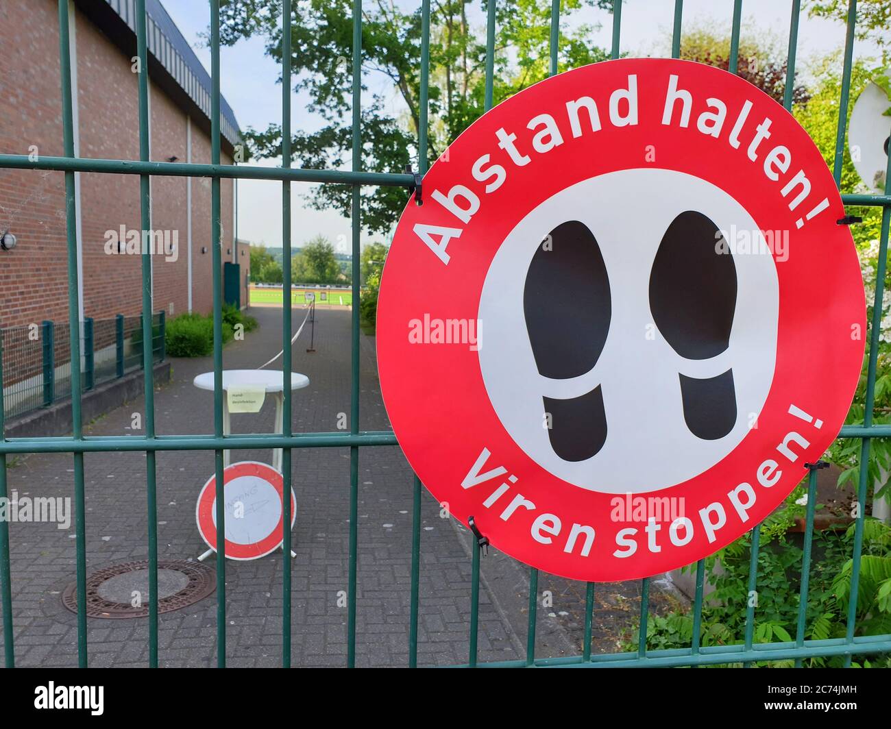 sign Abstand halten - Viren stoppen at a fence, keep distance, stop virusus, Germany Stock Photo