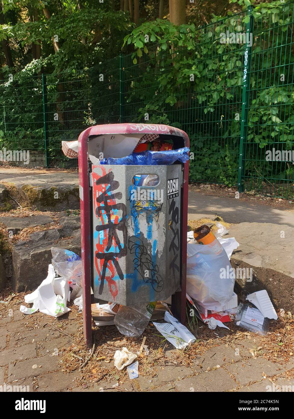 overfilled trash can on a parking lot, Germany Stock Photo Alamy