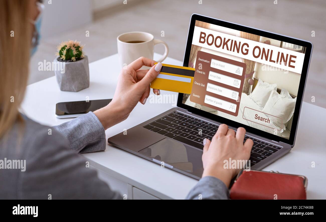 Businesswoman making online reservation, using laptop at workplace Stock Photo