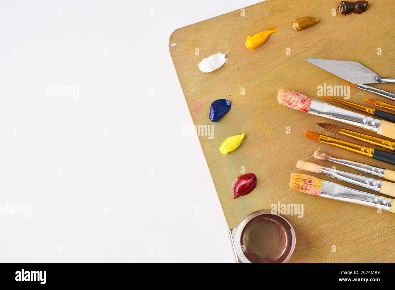 palette with paints and brushes for oil painting on a white background Stock Photo