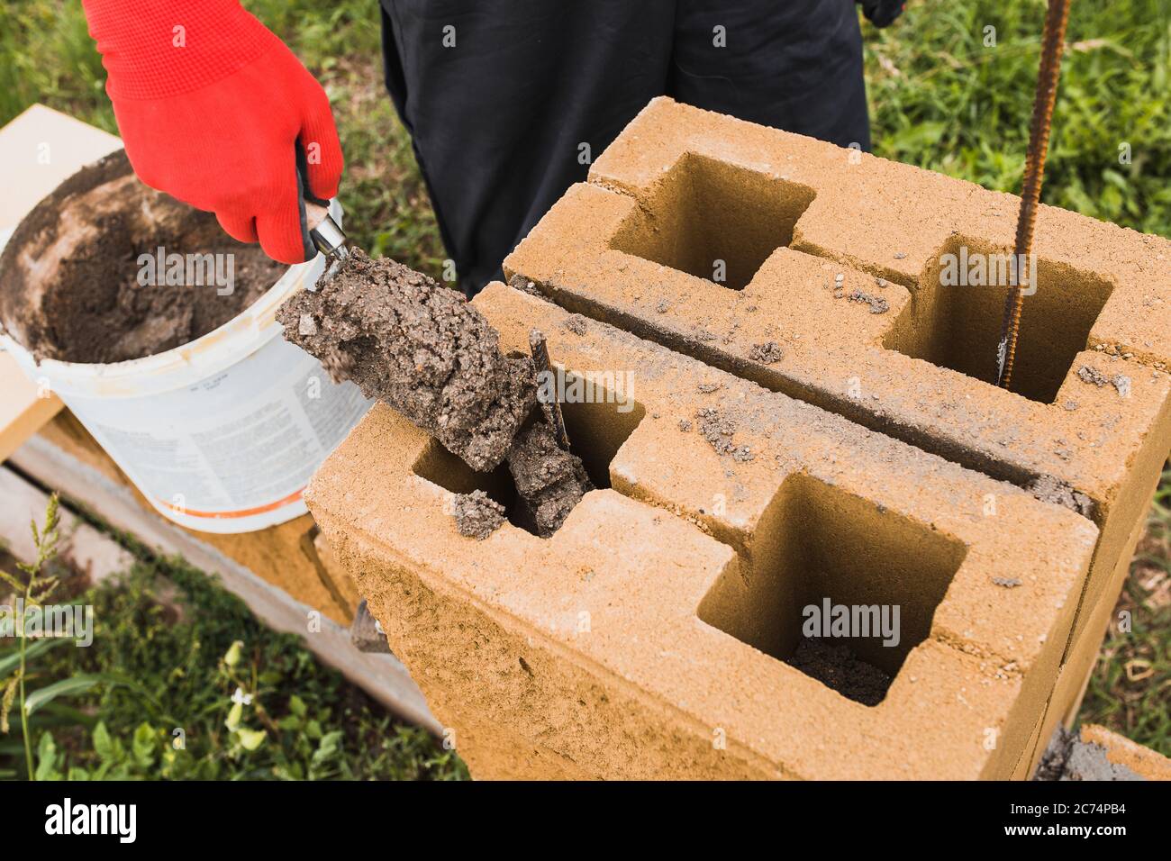 Professional masonry of building concrete blocks with filling empty cavities with concrete