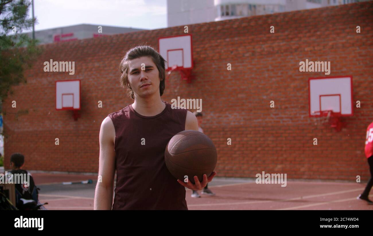 Young man on basketball holding the ball. Mid shot Stock Photo
