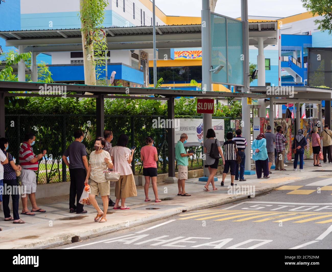 SINGAPORE – JULY 10 2020 – Elderly Singaporean voters wearing protective masks and maintain social distancing while queuing to vote outside Peiying Pr Stock Photo