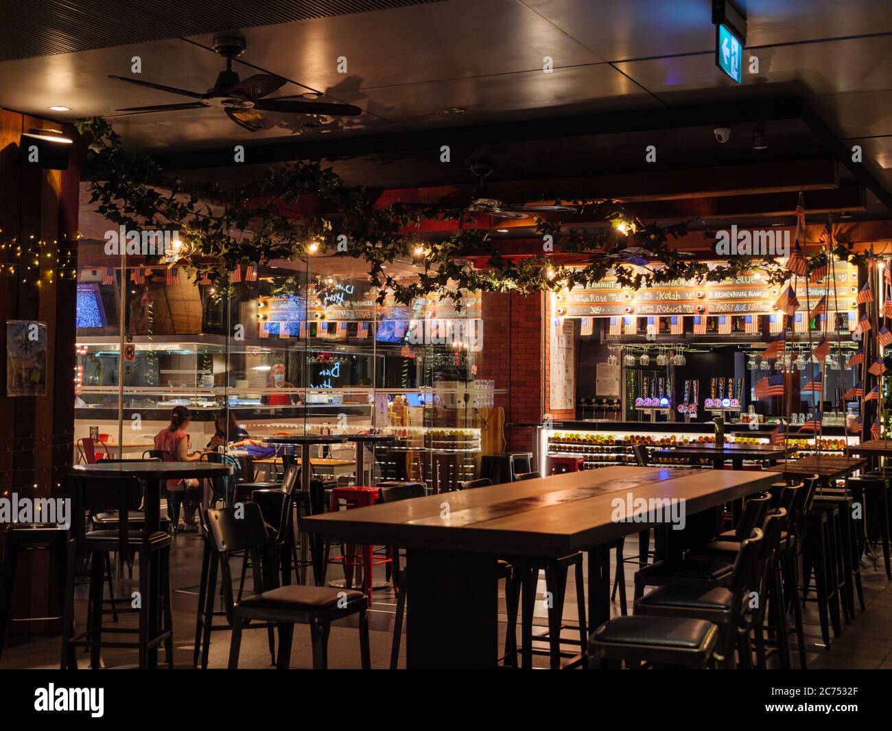 SINGAPORE – JULY 08 – Empty tables with only two customers at Morganfield’s American bar and restaurant at Orchard Central Mall, Orchard Road, Singapo Stock Photo