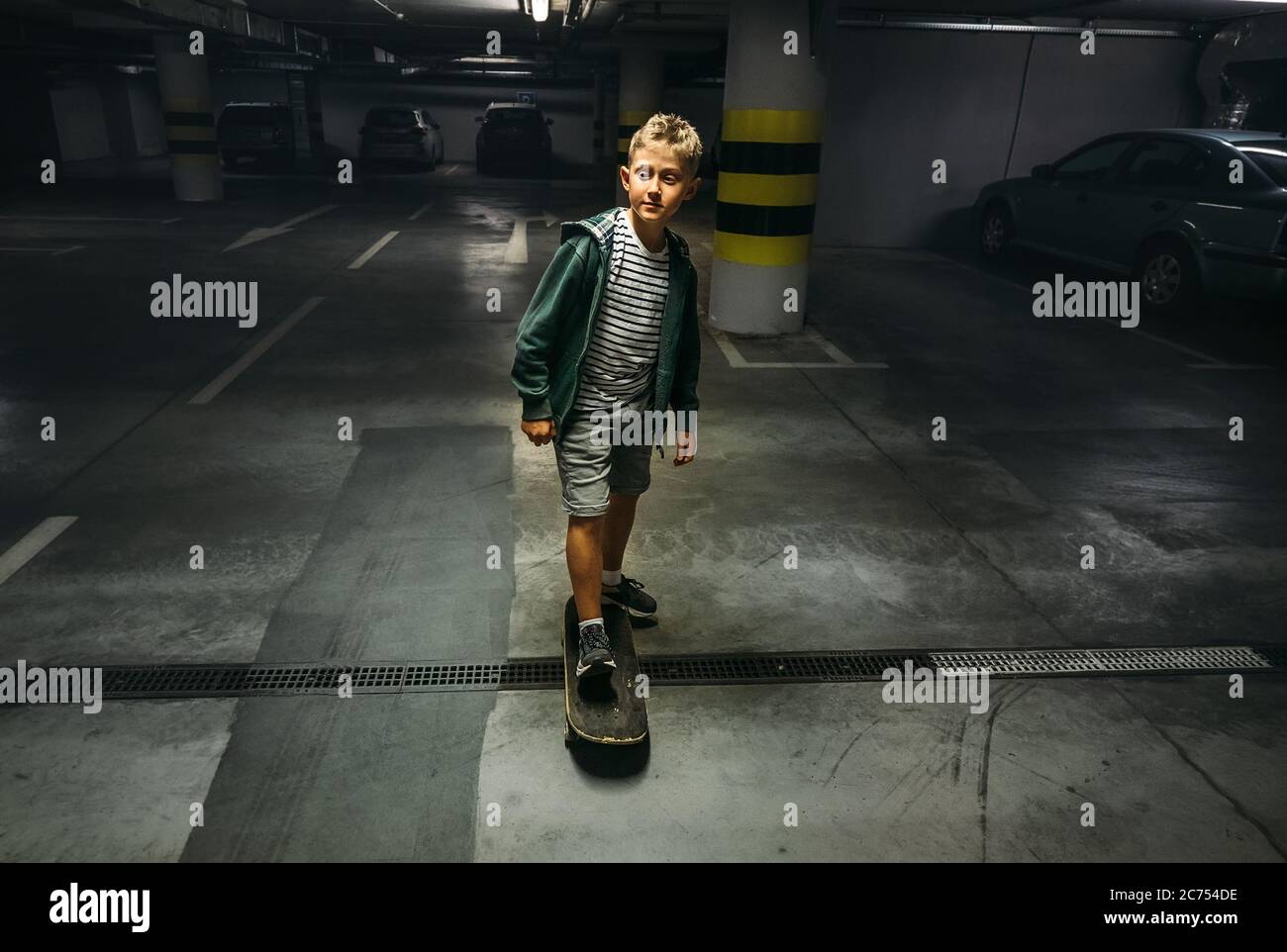 Boy skates on skateboard in undeground parking Stock Photo
