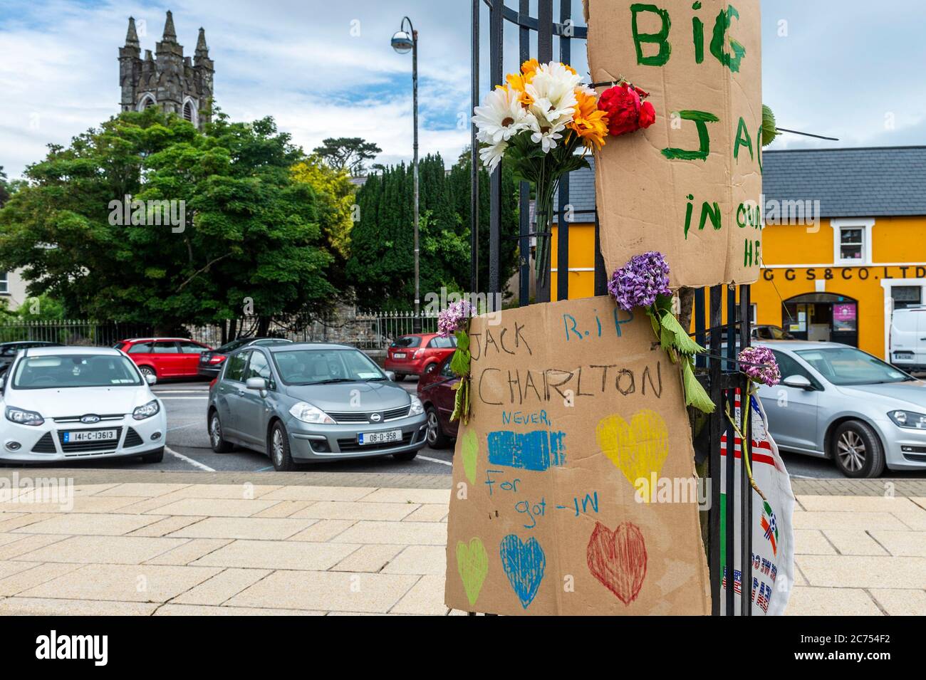 Bantry, West Cork, Ireland. 14th July, 2020. A tribute to the late Jack Charlton, who died on Friday, has appeared in Bantry Square. Created by local, Sean Kelly, whio didn't want to be photographed, the tribute consists of messages on two pieces of cardboard, candles and flowers. Another Jack Charlton fan also placed a flag. Credit: AG News/Alamy Live News Stock Photo