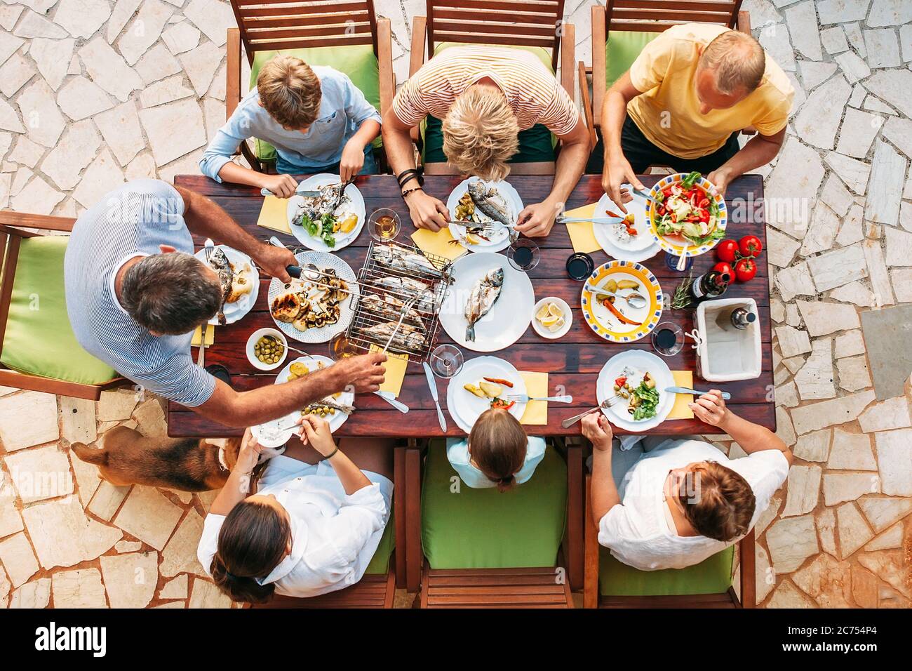 Big miltigeneration family dinner in process. Top view vertical image on  table with food and hands Stock Photo - Alamy