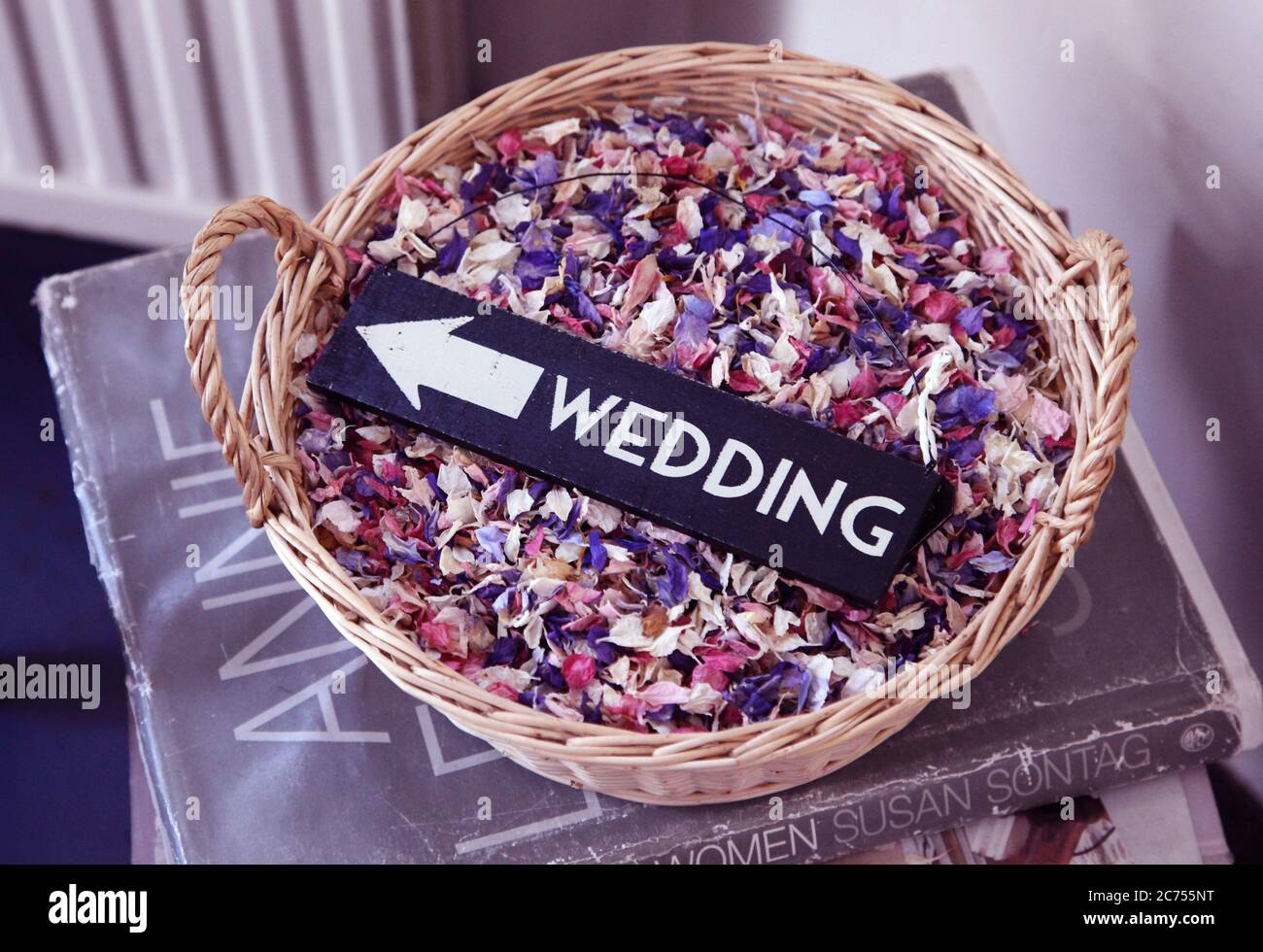 Wedding written text sign on wicker bowl of natural dried flower petal biodegradable confetti. Stock Photo