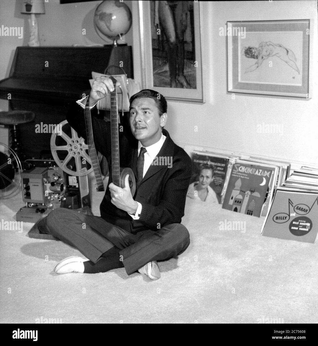 Comedian and television game show host Bob Monkhouse at home looking through his collection of silent movies Stock Photo